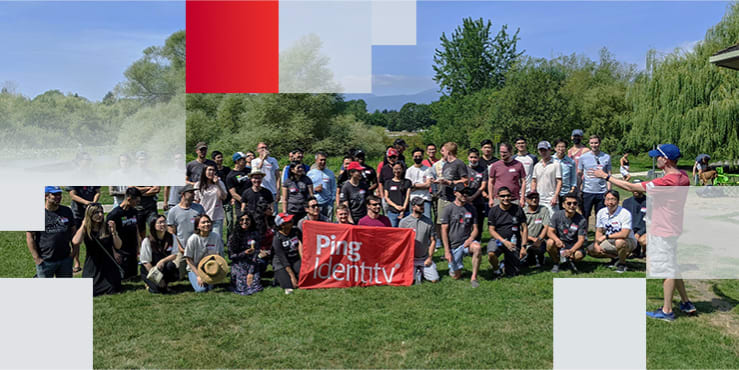 Decorative graphic containing photo of a large group of PingIdentity employees smiling, holding up a red PingIdentity banner and posing for a picture together outside.